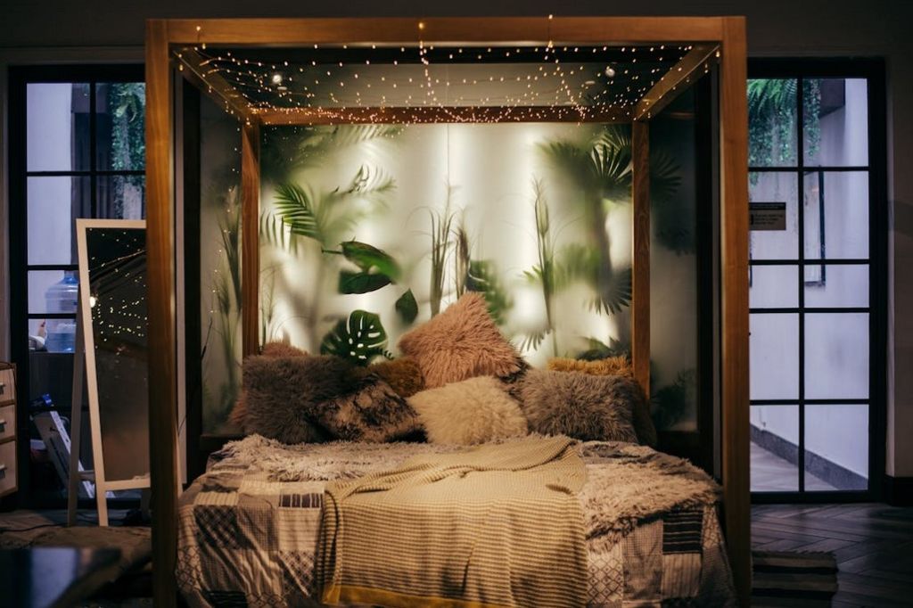 A very cozy looking bedroom with lights hanging from a canopy bed frame