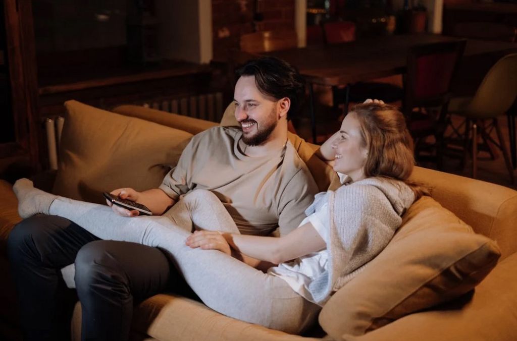 A couple lounging on the sofa in their livingroom, evening