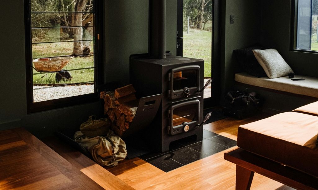 Cozy black fireplace in a room with large windows, during the day