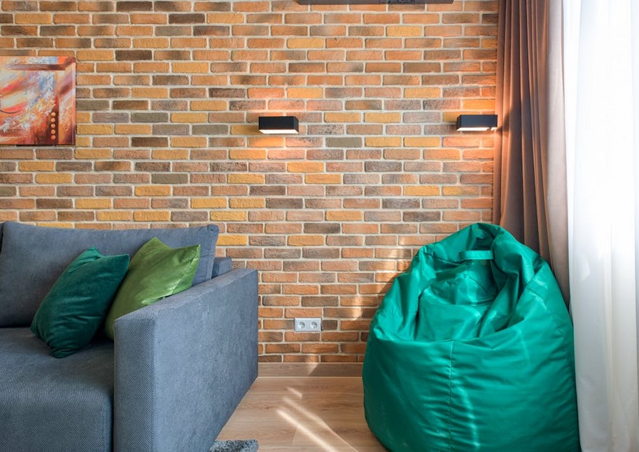 A green bean bag in the corner of a brightly lit room