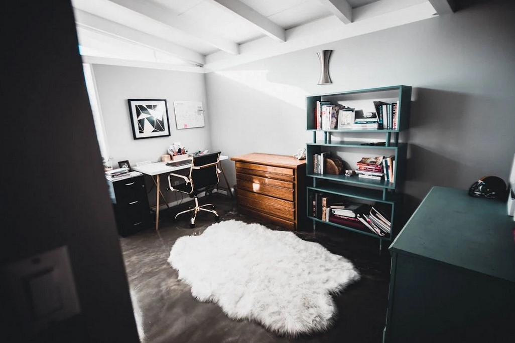 Bedroom converted into a home office, light colors, dark accents, during the day time