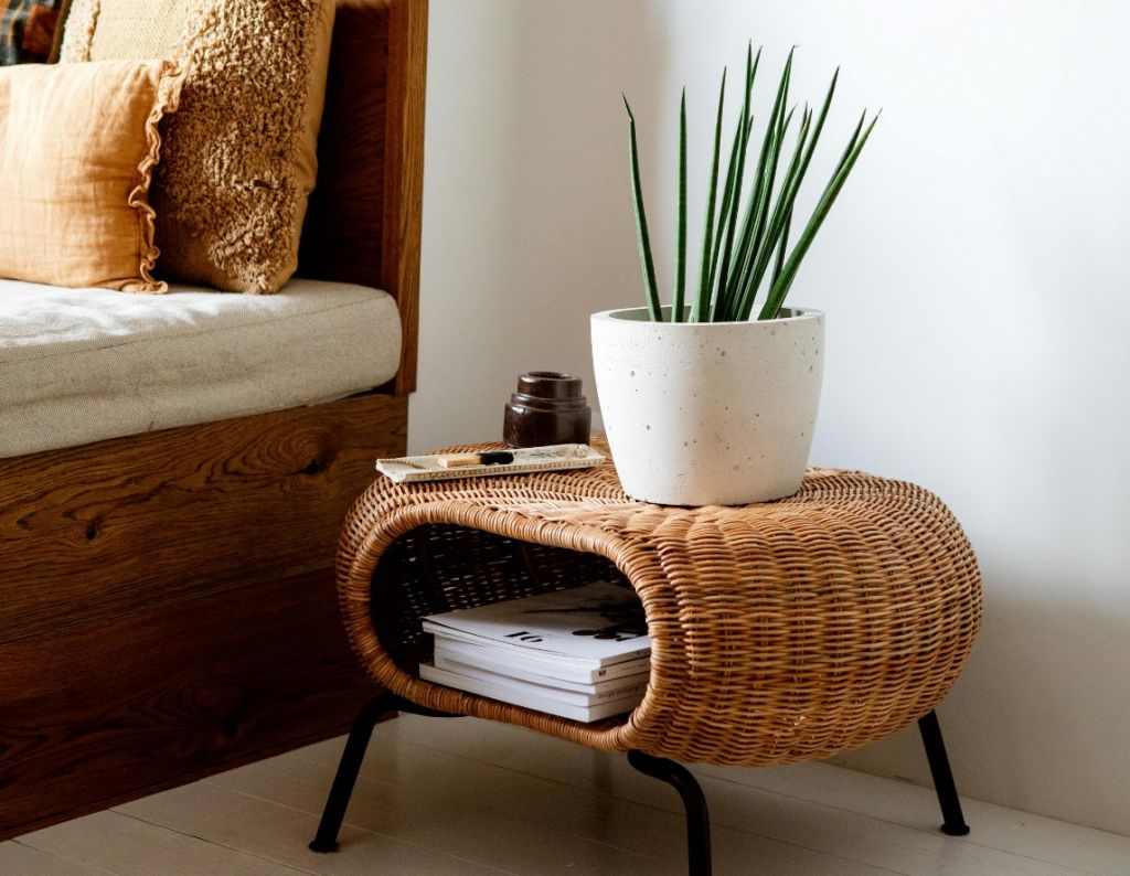 Rattan bed side table, natural materials, stylish table with potted plant decoration on top