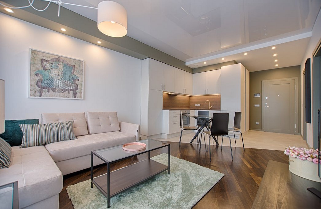 A stylish spacious apartment, many ceiling lights, light colors with green accents