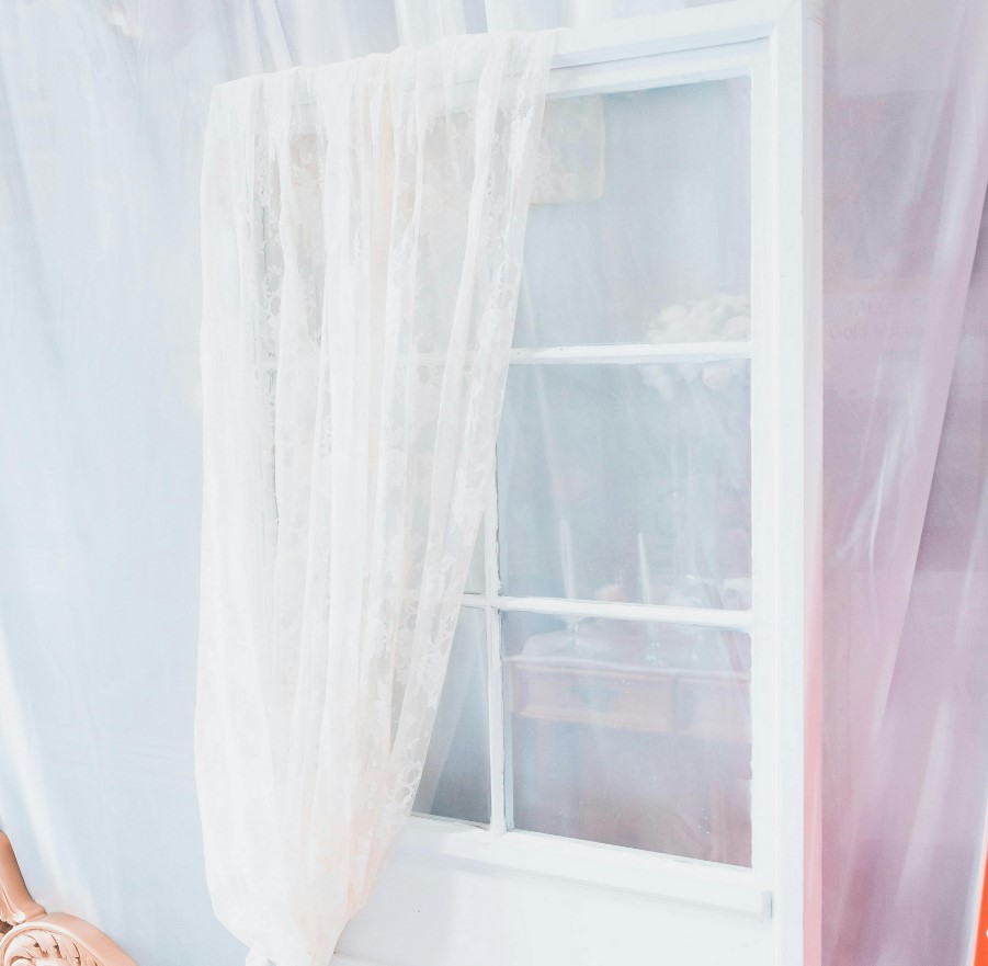 White glass door with white curtain draped over