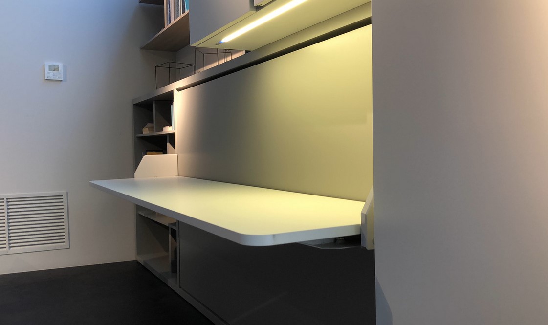 A fold out, built-in shelf in a small apartment
