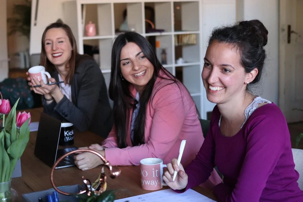 A group of 3 women laughing in a room