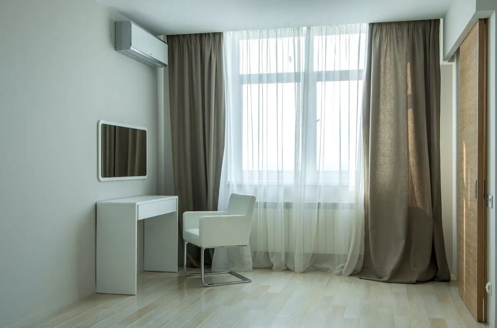 A sparse modern room with sheer curtains