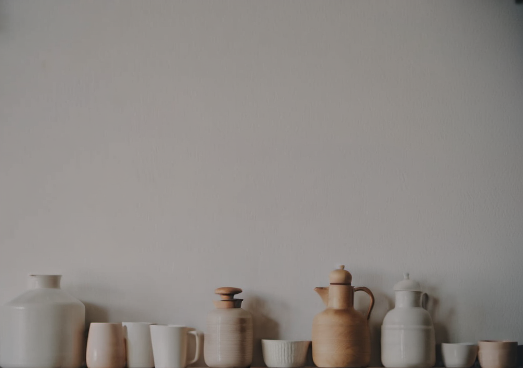 Collection of jars and cups on a wooden shelf