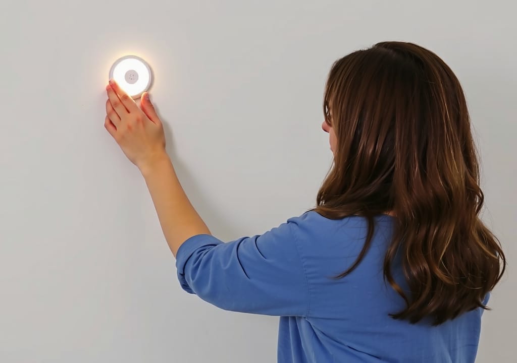Woman in blue shirt placing light puck